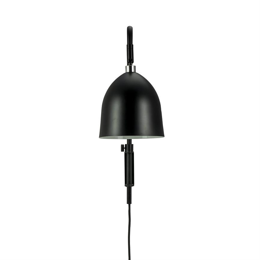 Black wall lamp hangs mounted with dome-shaped shade, directs the light downwards; has adjustable arm and visible black cord against a neutral white background.