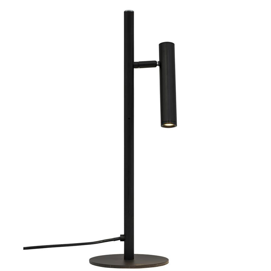A slim, black desk lamp with a vertical rod and cylindrical lamp head that points downwards and emits a dim light; stands on a round base against a white background with visible wire.