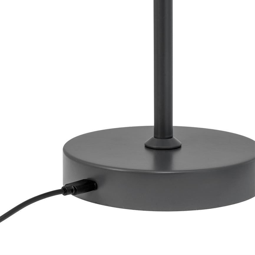 Black lamp base stands vertically from a round, flat base; a black power cord is connected at the side of the base on a white background.