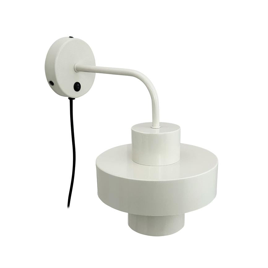 Wall lamp with white, round shade and cylindrical top, mounted on a circular wall plate via a curved arm; black wire hanging down, photographed against neutral white background.