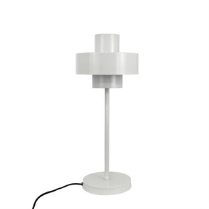 Hvid bordlampe står på en rund fod; en slank metalstang fører op til en to-lags cylindrisk skærm. Lampen er placeret mod en ensartet hvid baggrund, med sort ledning til venstre.