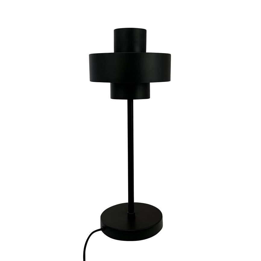 Black modern table lamp stands vertically; cylindrical two-piece shade, thin rod and round base with attached cord, set against uniform white background.