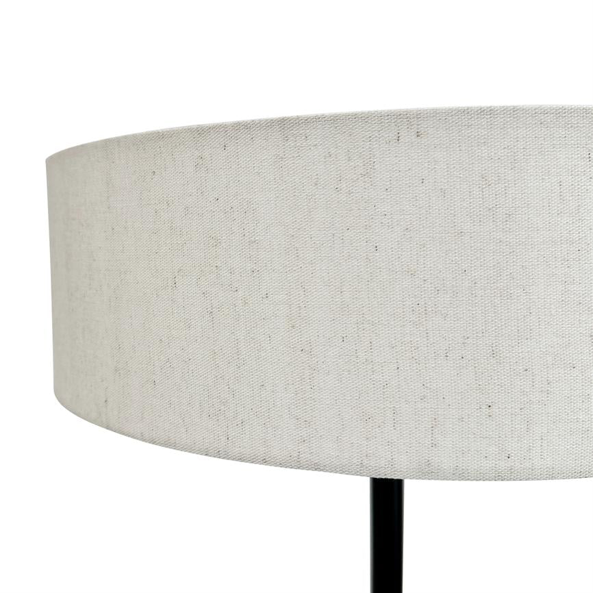 Lampshade in light, melange fabric rests on a slim black lamp base; close-up of a cylindrical shape against a uniform white background.