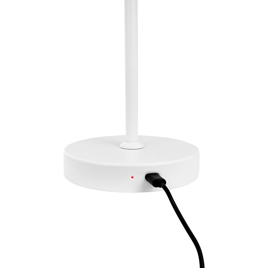 White round lamp base with vertical pole, where a black USB cable is connected and a small red LED light is on, against a uniform white background.