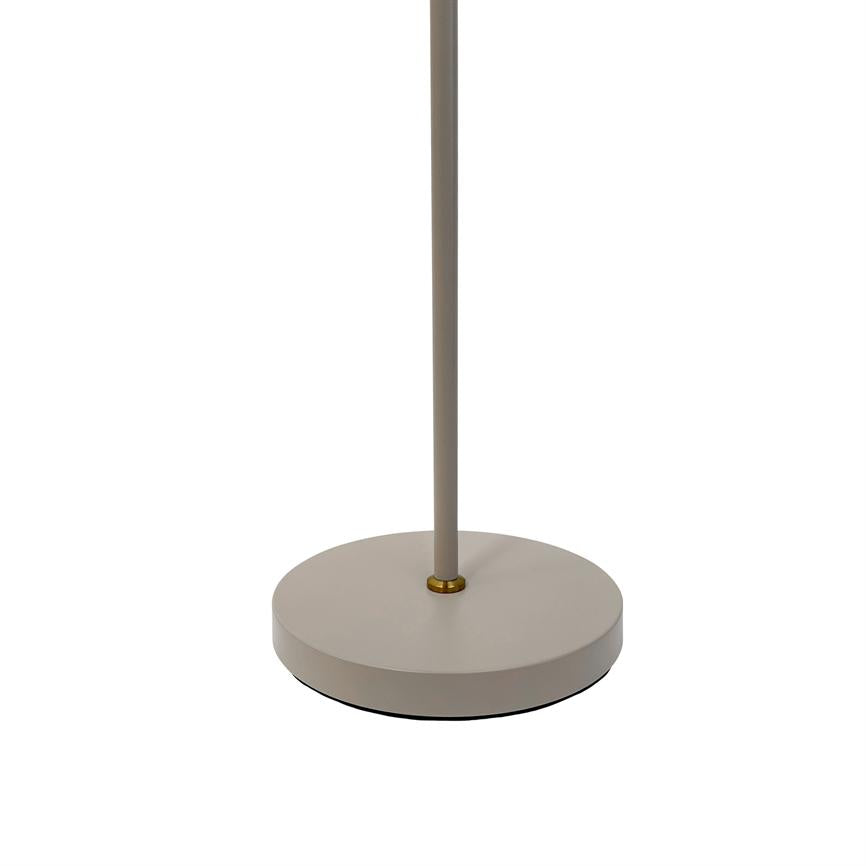 Lamp base with slim rod: beige metal base and thin rod connected by a small brass ring; stands on a uniform white background in a minimalist studio.
