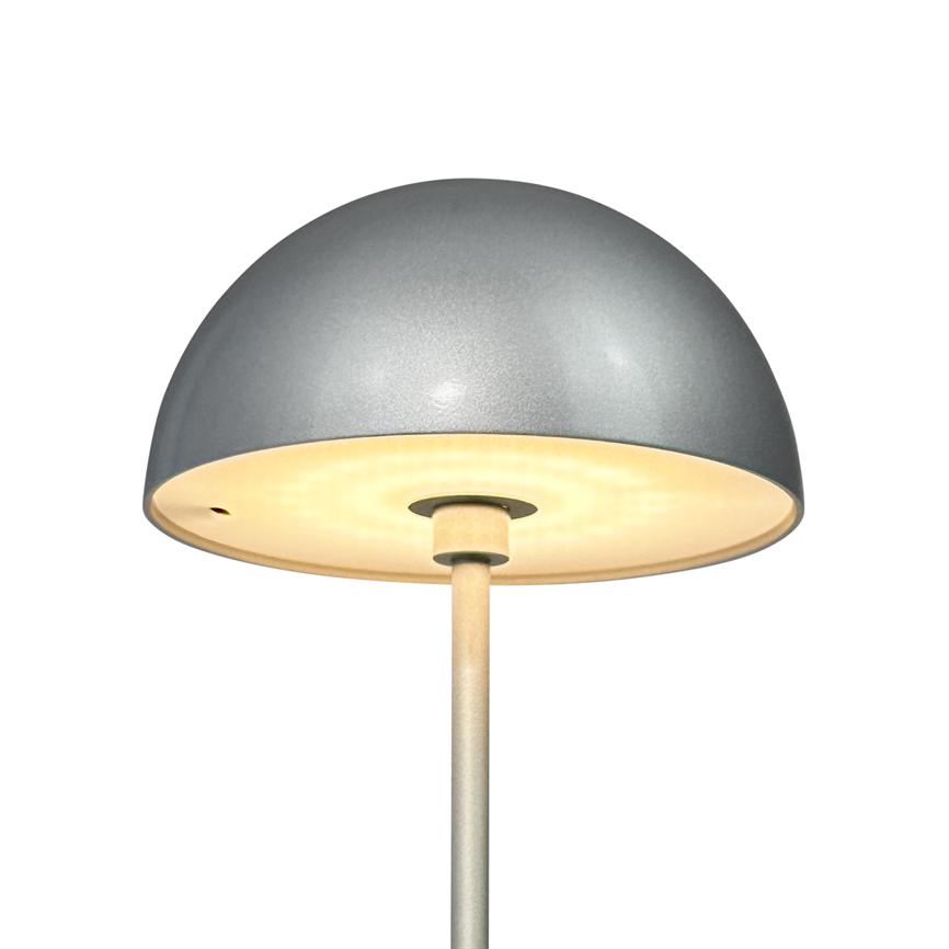En grå, halvkugleformet lampe lyser med varmt indre lys; dens hvide inderside, centrale metalliske stang og matte overflade ses mod en ren hvid baggrund.