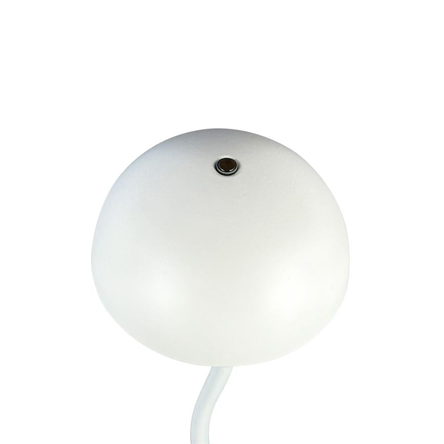 A round white lamp with a small metal button at the top sits on a curved white base, isolated against a uniform white background.