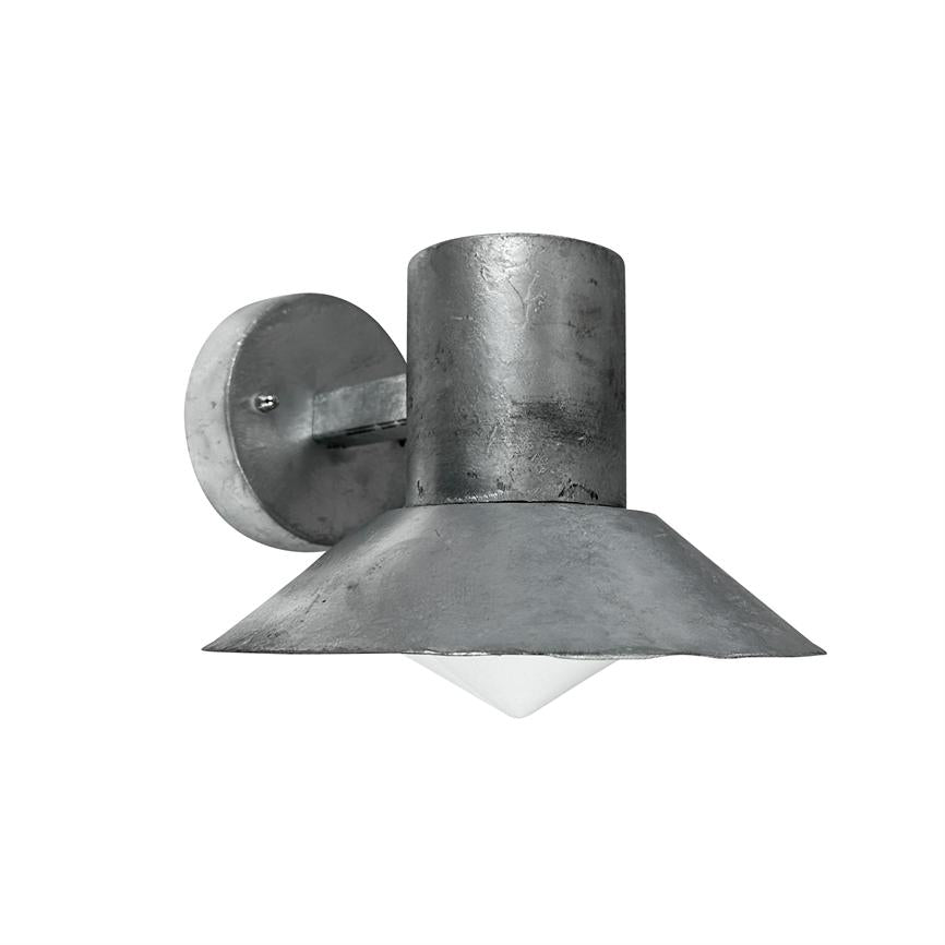 Metal wall lamp hangs, casts light downwards; raw, dark gray cylinder-shaped fixture with wide, slanted shade and white pyramid-shaped diffuser, mounted on round wall plate in similar metal.