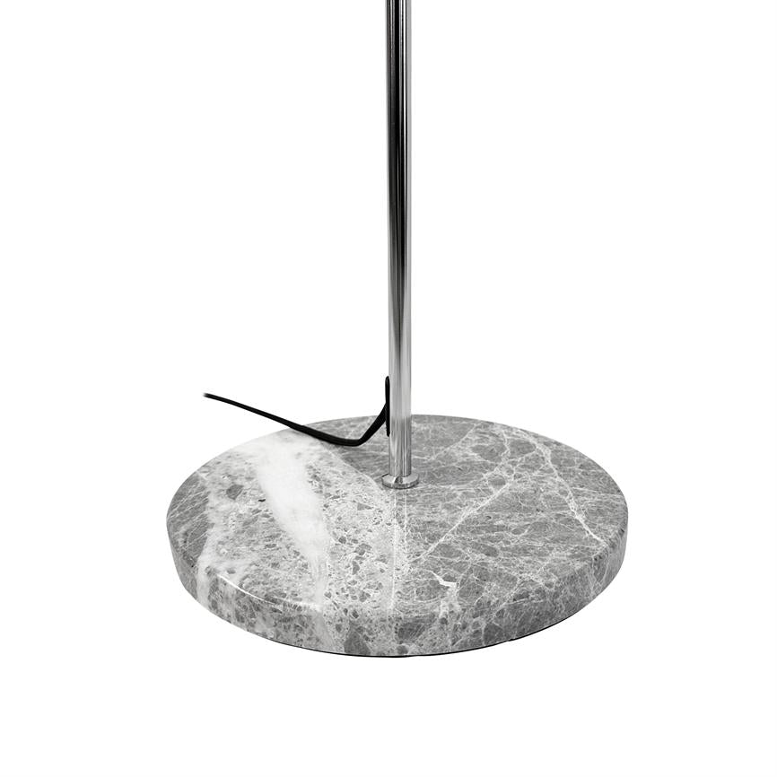 Round marble base supports a vertical chrome rod; a black power cord lies partially twisted on top of the base, the object stands isolated against a neutral white background.