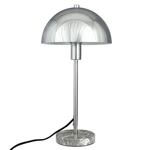 A chrome, mirror-gloss table lamp with mushroom shade stands on a round gray marble base with slender metal rod and black cord, set against a uniform white background.