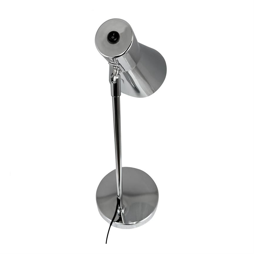 Silver, chrome-plated table lamp stands vertically; tilting cone-shaped shade points obliquely downwards, round foot rests on white background, black cord hangs down along the frame.
