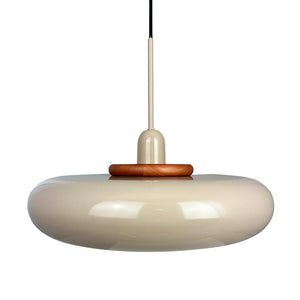 A round, beige glossy ceiling lamp hangs from a thin rod and black cord; the screen is donut-shaped with a wooden ring at the top, minimalistic white background.