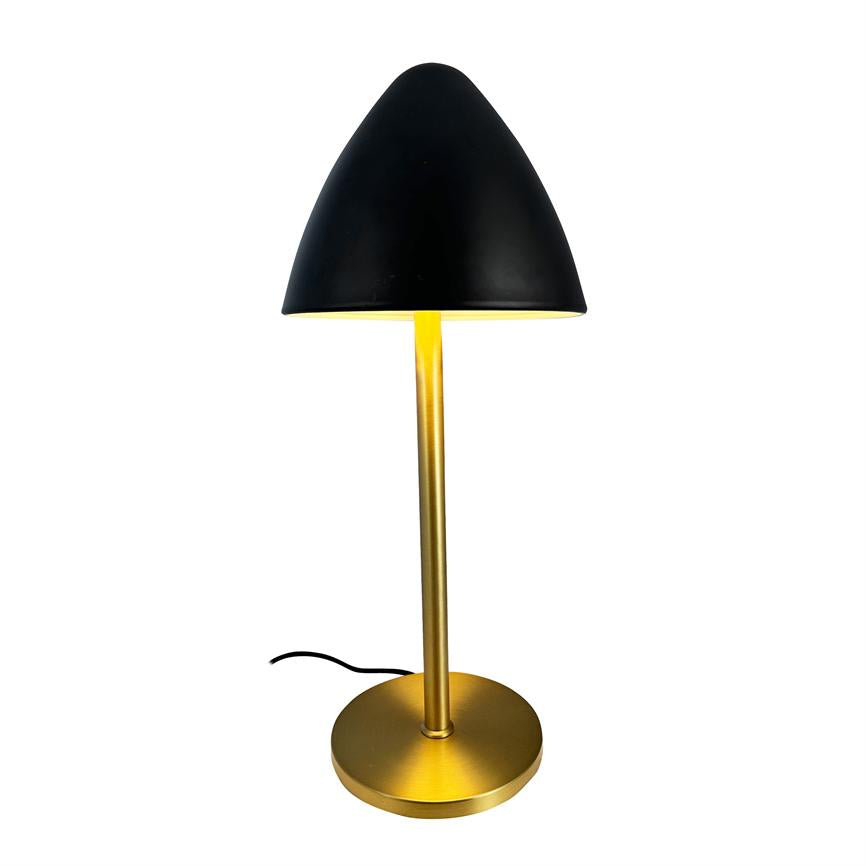 Table lamp with black cone-shaped shade, emits warm light; slim gold colored rod and round base stand on white background with visible black power cable.
