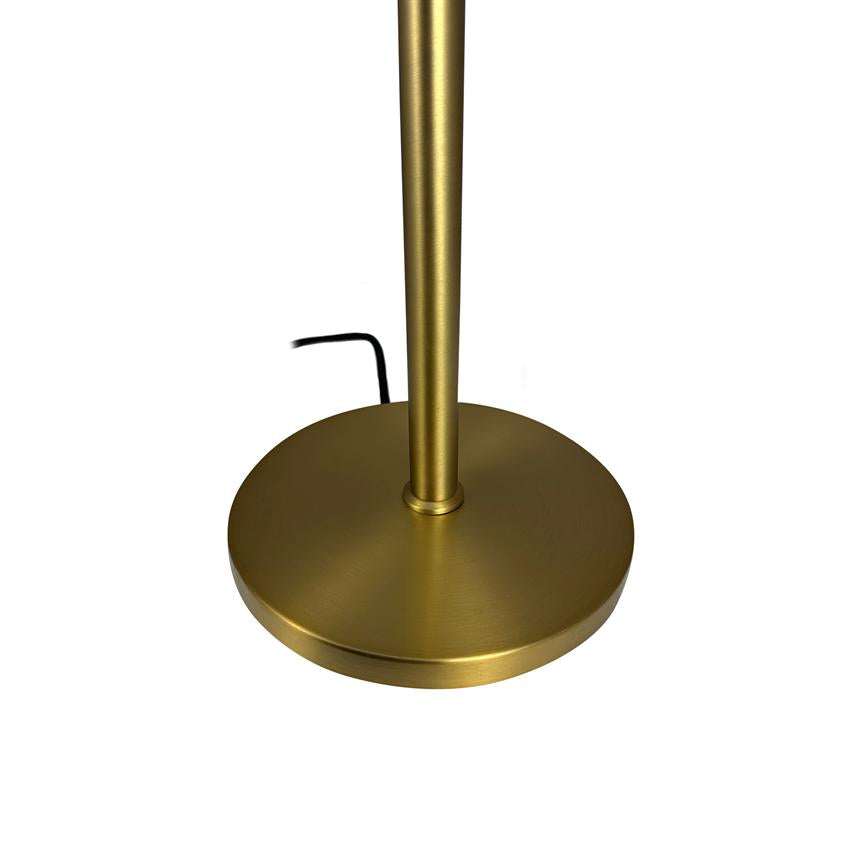 A round, gold-colored lamp base supports a vertical rod; a black wire sticks out on a uniform white background.