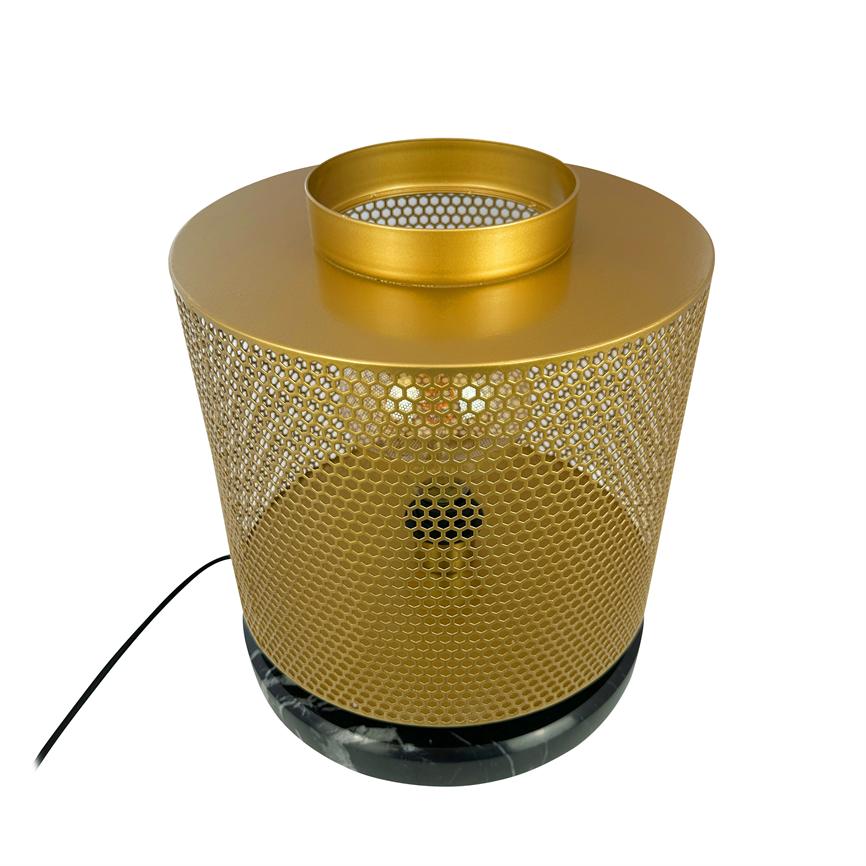 Gold-coloured, cylindrical metal shade with hexagonal perforations emits warm yellow light from within; stands on black marble base with black cord, photographed against white background.