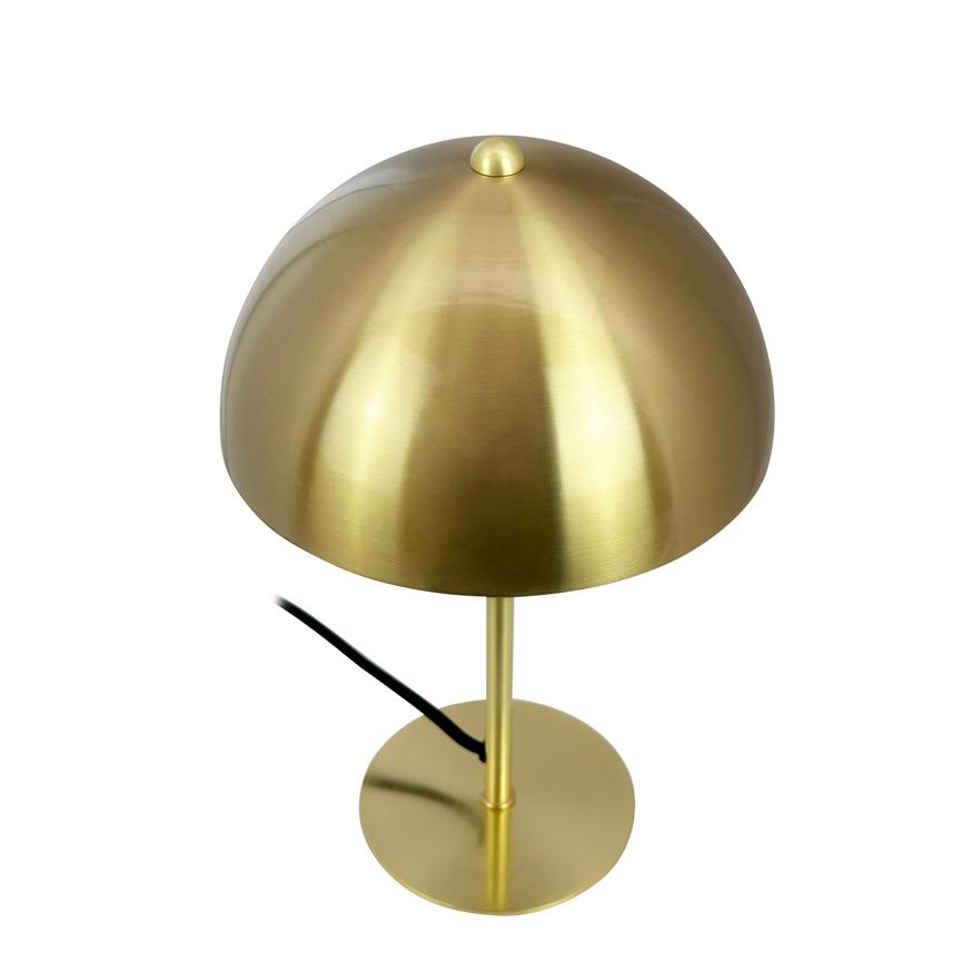 En messingfarvet bordlampe med svampeformet kuppel står på en slank lodret stang og rund fod; en sort ledning løber langs stangen, alt placeret mod en neutral hvid baggrund.