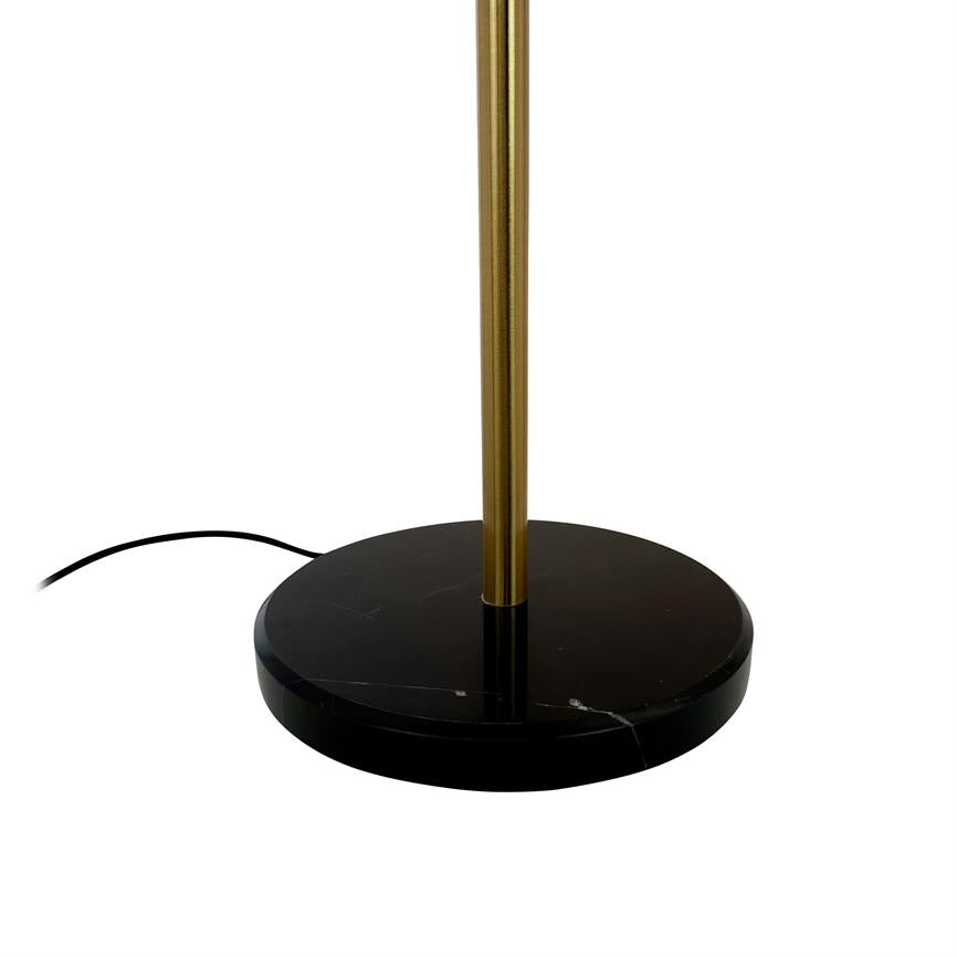 Lamp base stands on a round, black marble base and carries a slender gold-coloured rod; a black wire runs partially visible over white background.