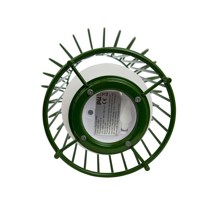 A green metal cage lantern shows its underside; a round white battery cover with sticker is seen through the players against a pure white background.
 
 Text on label: IP44 CE
