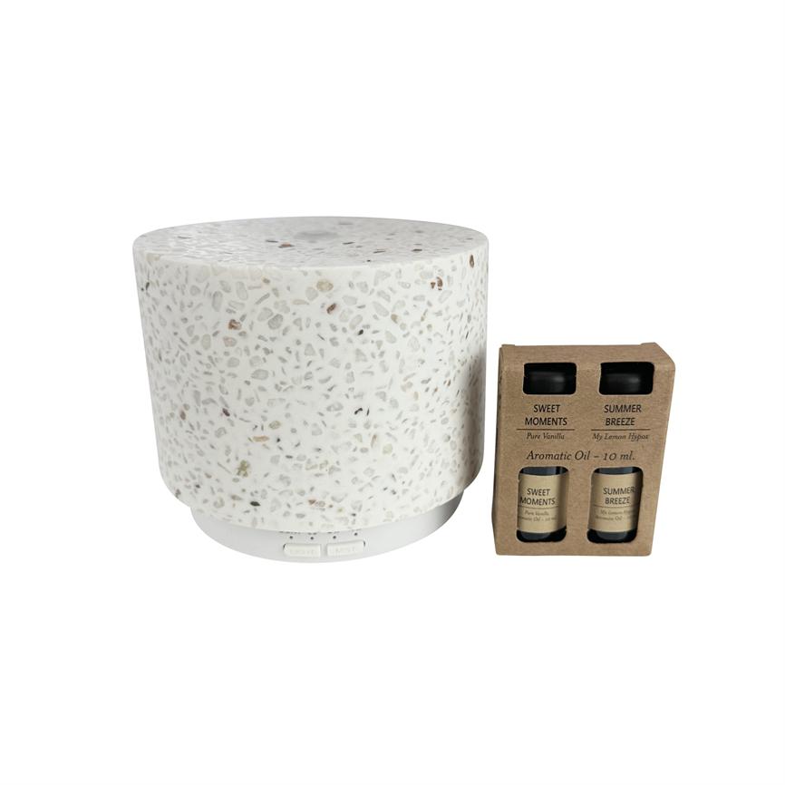 A white terrazzo aroma diffuser stands next to a cardboard box with two small aromatic oil bottles on a white background.
 
 Text: 
 SWEET MOMENTS
 Pure Vanilla
 SUMMER BREEZE
 My Lemon Verbena
 Aromatic Oil - 10 ml.