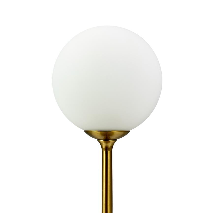 A white opal glass globe mounted on a slender, gold-toned brass rod; simple, uniform white background in a minimalist studio setup.