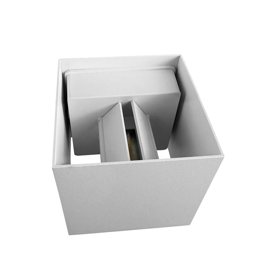 Cube-shaped white lamp shows an inner module with two vertical screens around a visible light source, photographed obliquely from above against a neutral white background.