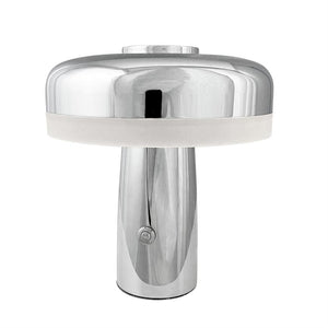 Bordlampe i poleret krom, svampeformet skærm med hvid diffuserring; den står på en glat cylindrisk fod med tændknap foran, placeret mod en neutral hvid baggrund.