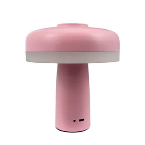 Lille rosa svampeformet bordlampe står oprejst; basen har USB‑C‑opladeport og indikator, placeret mod en neutral hvid baggrund.