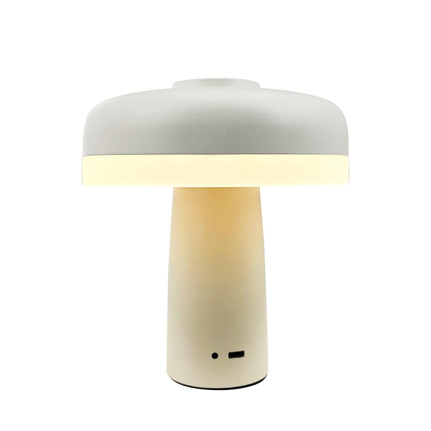 Table lamp glows warm and evenly with a soft light band at the edge of the lampshade; simple mushroom shaped screen and cylindrical base, cream white surface, USB port at bottom, alone on white background.