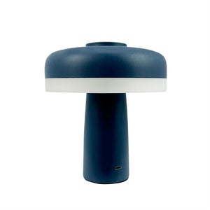 Mushroom-shaped table lamp stands on white background; dark blue top and base with white light ring, USB-C charging port visible at the bottom.