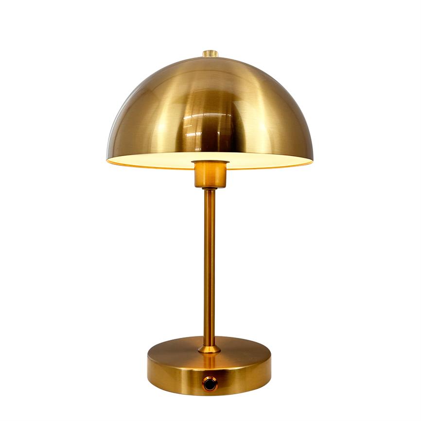 Gold-colored table lamp with hemispherical shade, casts soft light downwards; slim rod and round foot with small black switch, placed in front of white background.