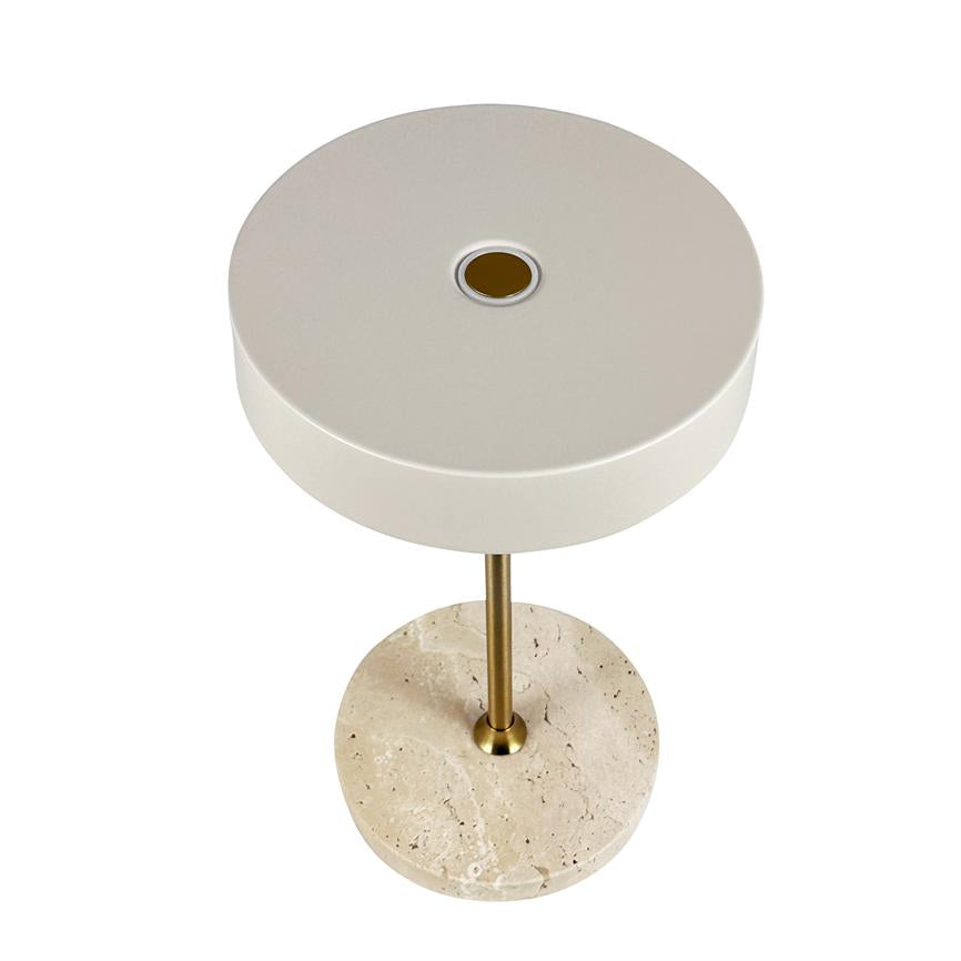 Table lamp with large, circular, matt white shade; rests on a slender brass rod mounted in a round, beige marble base; isolated against a clean white background.