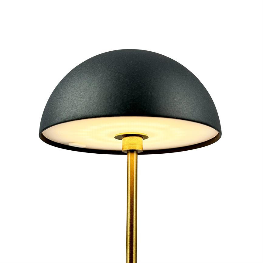 Black hemisphere lamp emits soft, warm light downwards; mounted on a thin, gold-colored rod against a clean, white background.