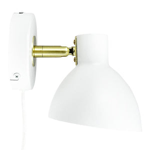White wall lamp turned downwards via a brass link, attached to a round white wall plate with visible white fabric cord against a uniform white background.