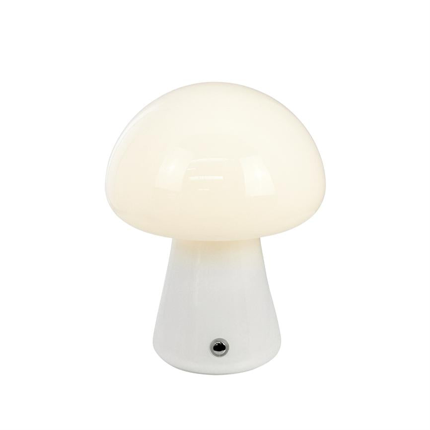 Table lamp shaped like a mushroom, emitting soft warm white light, with round opal shade and cone-shaped base with small metal contact at the front, placed against a uniform white background.
