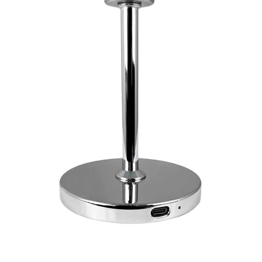 En krom lampefod står stabilt og har en USB‑C-port; en slank poleret stang rejser sig fra den runde base på en neutral hvid baggrund.
