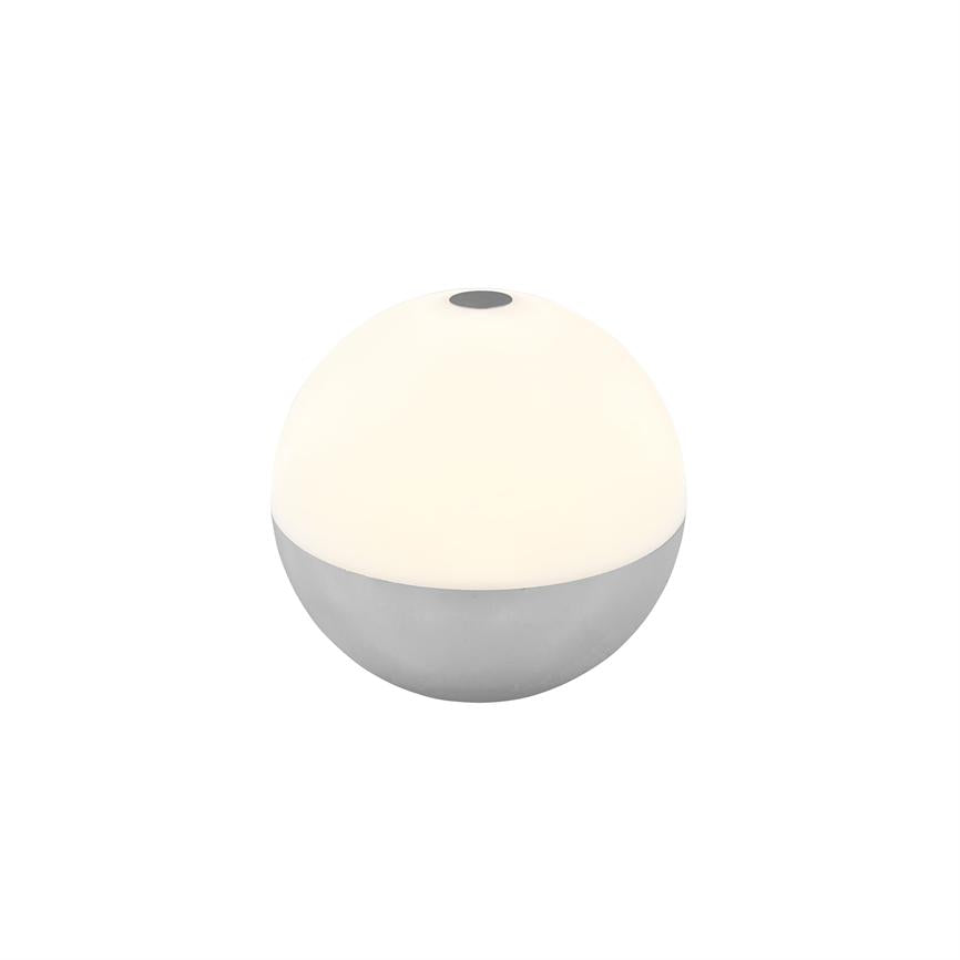 Round table lamp (hemisphere) glows softly; upper white half emits warm light, lower half is metallic gray; small black push button on top, placed on white background.