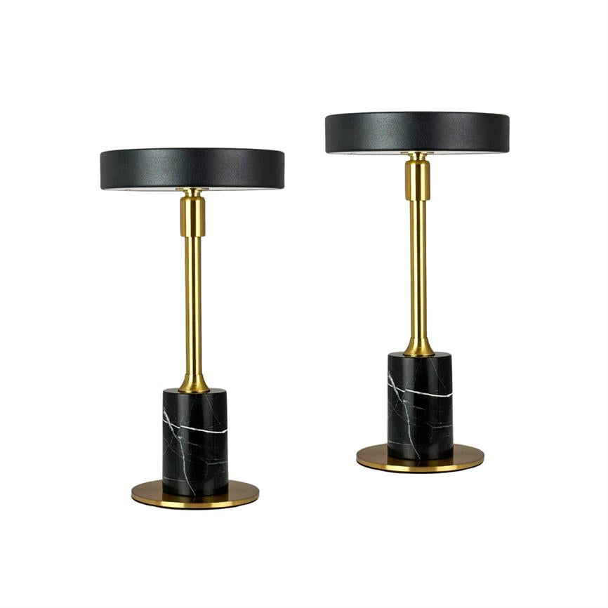 Two table lamps stand side by side on a white background; black round shades, golden rods and black marble bases with white veining on round golden plinths.