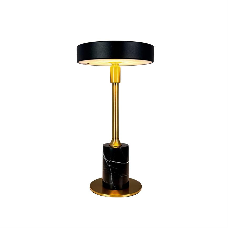 Table lamp with black, flat shade, golden center rod and black marble base with white veins; glows warmly downwards and stands on a plain white background.