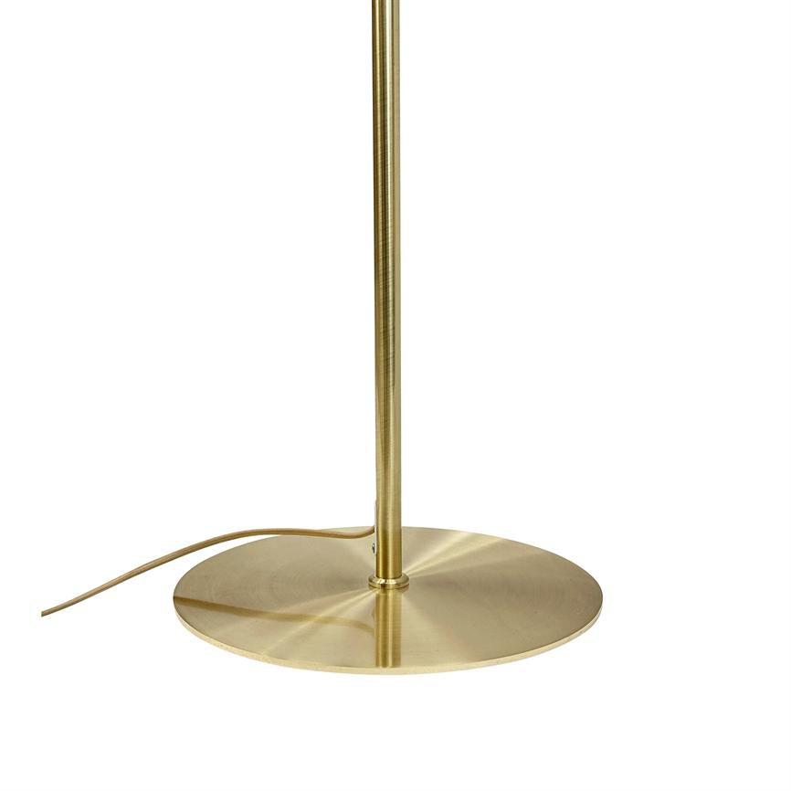 Gold colored floor lamp base: slim vertical rod attached to flat round metal base; power cord runs from foot — minimalistic white background.