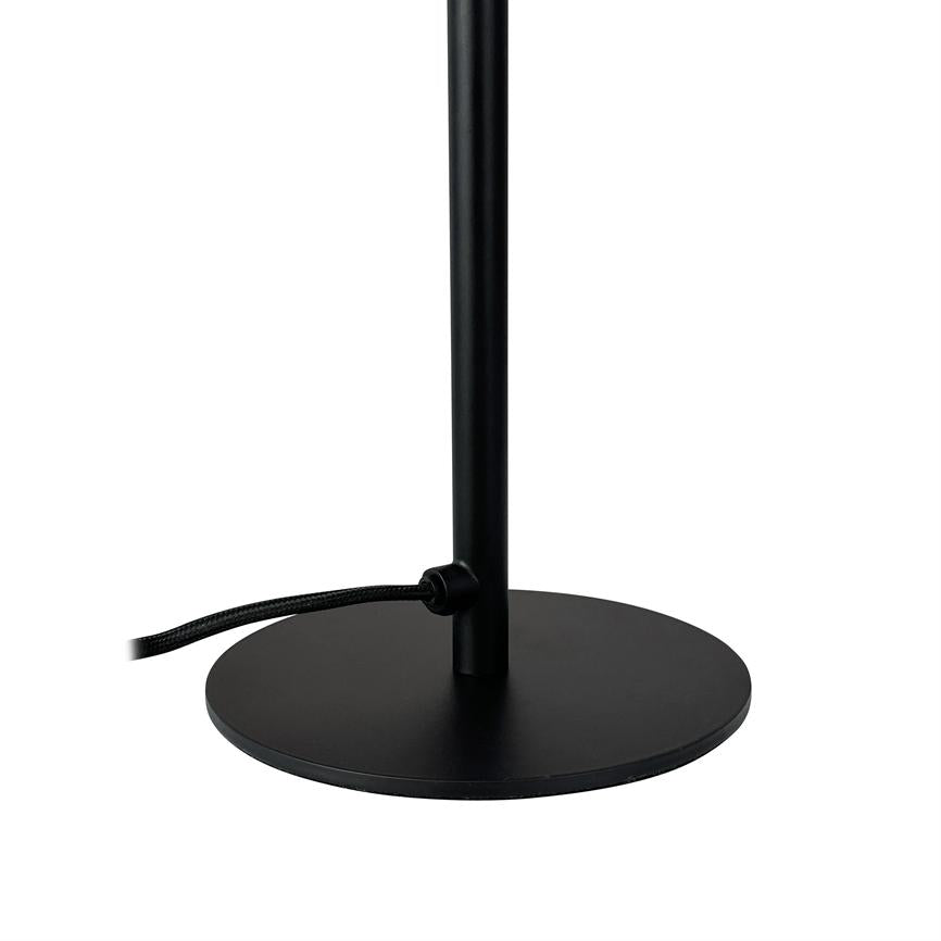 Black lamp stand with round, flat base; a vertical rod rises from the center and a cloth-covered cord runs out through a small holder to the left, against white background.
