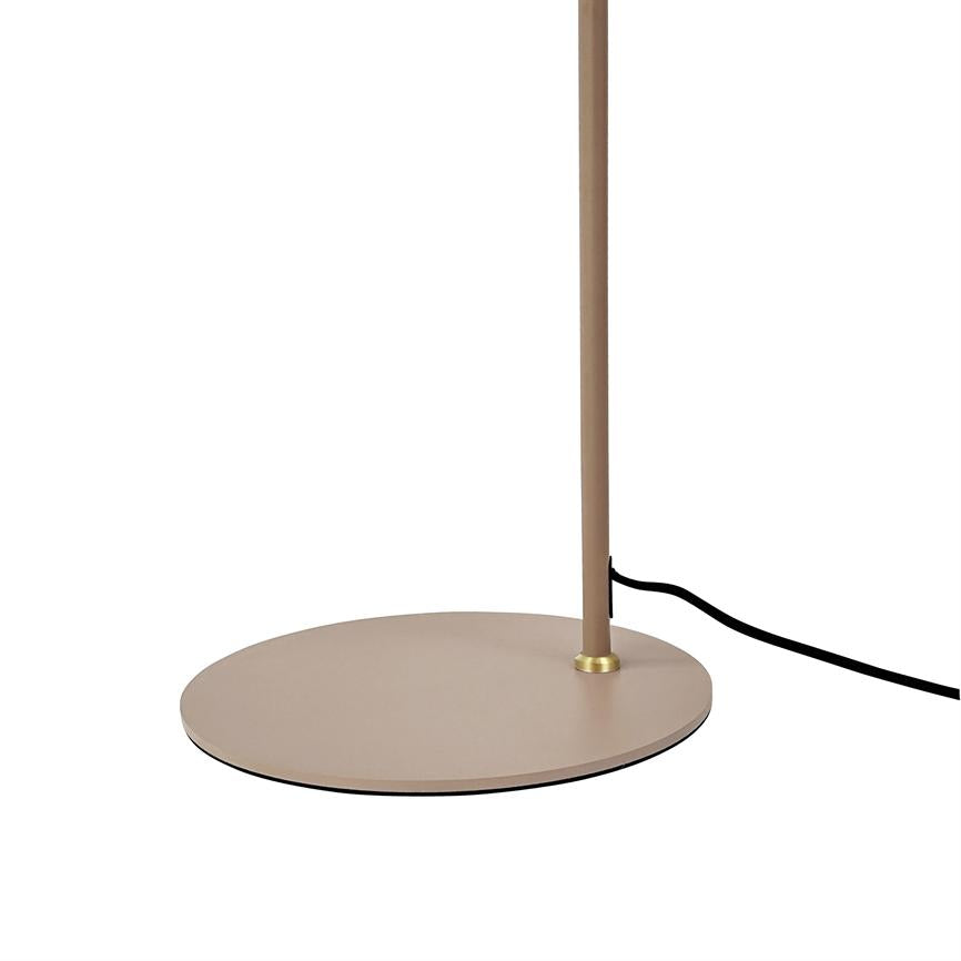 Lamp base: a slender vertical rod mounted on a flat, round beige metal base; a black power cable runs out to the right on a white background.