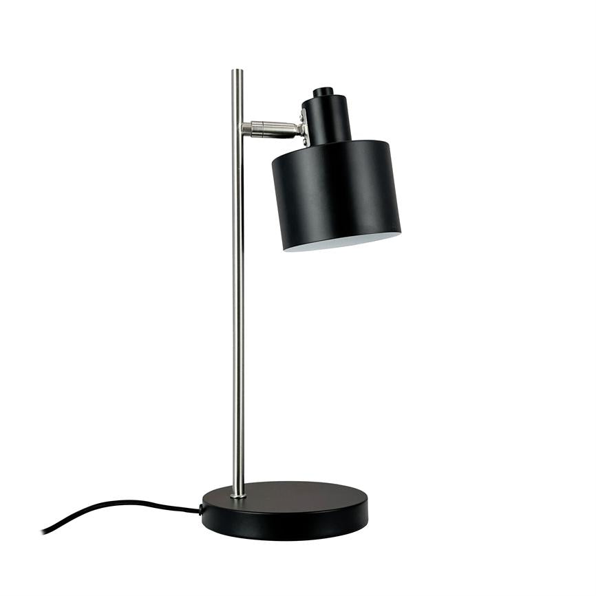 Skrivebordslampe med sort cylindrisk skærm, vipbar hoved, monteret på en slank sølvstang og rundt sort fod; sort ledning ligger ud til siden på hvid baggrund.