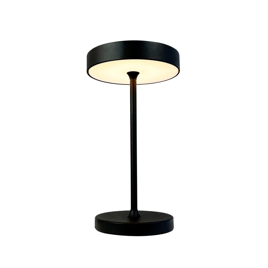 Black, modern table lamp with cylindrical base and thin rod, round upward-facing shade that emits warm, diffused light; presented against a neutral white background.