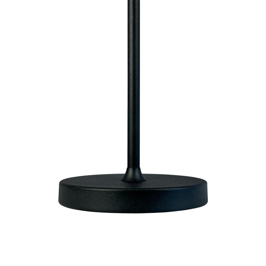 Black lamp stand in matt black metal stands upright on a round, flat foot against a white background.