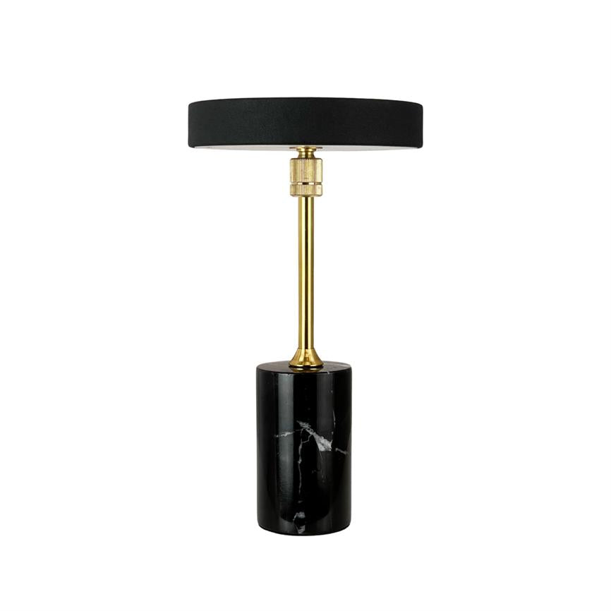 Black table lamp stands upright; a round black screen rests on a narrow gilded rod, which sits on a cylindrical black marble base on a white background.