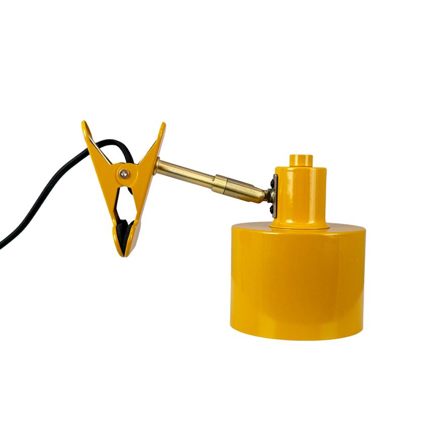 Yellow alligator clip mounted on an adjustable brass arm, connected to a round yellow magnetic base; a black power cable runs from the terminal. White, neutral background.