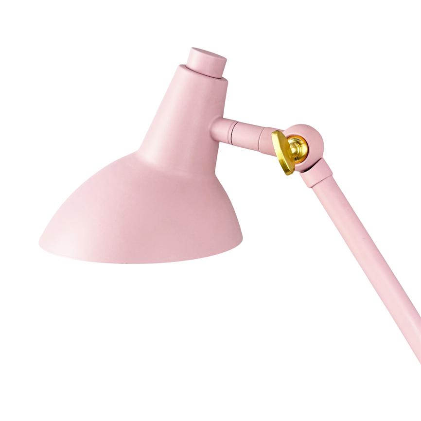 A pink adjustable desk lamp tilts its hemispherical shade downwards via an articulated arm with a gold-colored screw, set against a neutral white background.