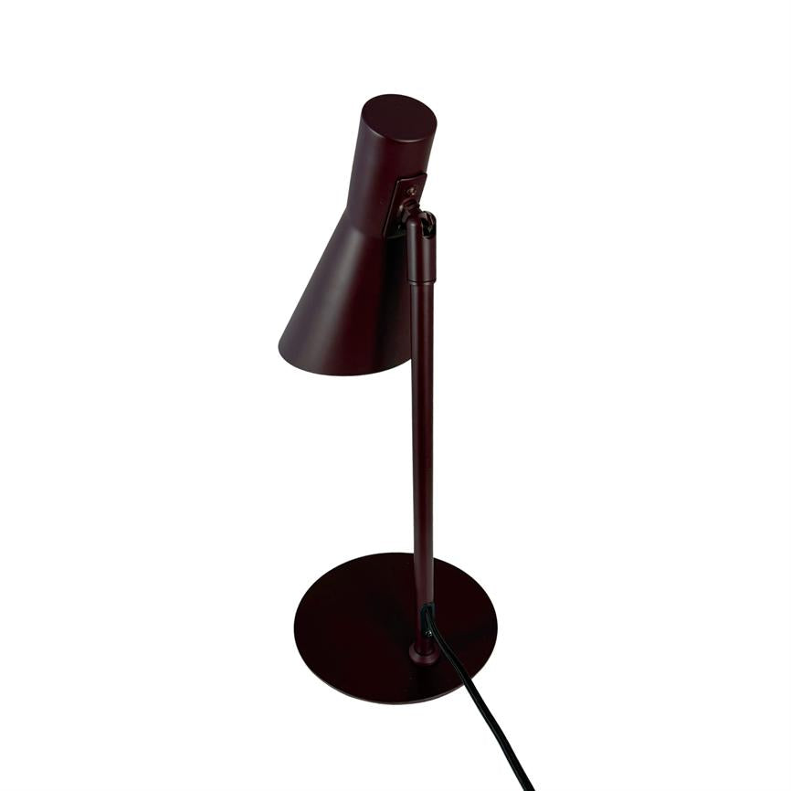 Table lamp with slim metal stand, angled conical shade points downwards; stands on a round base with visible black wire, set against a uniform white background.
