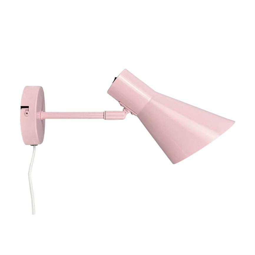 A pink wall lamp is mounted on a round wall bracket, has an adjustable arm and the shade is angled downwards to the right on a white background.