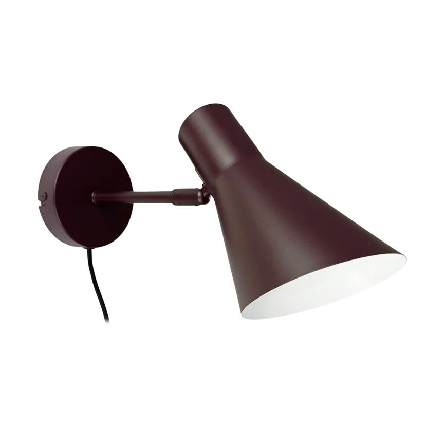 Wall lamp mounted on a round base, arm holding an angled conical shade which directs light downwards; dark brown outside, white inside and a black cable hanging down.